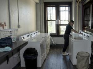 Student using laundry machines in Le Fer